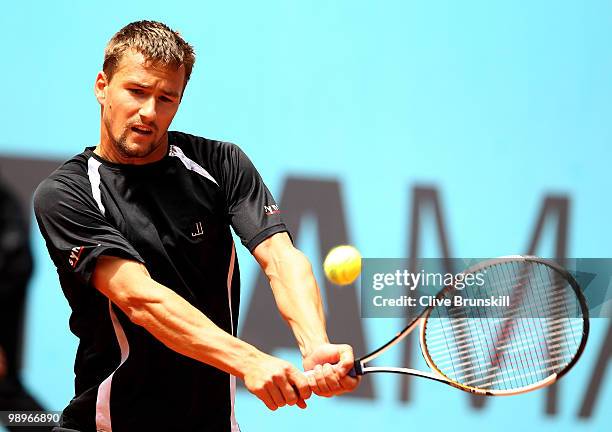 Marco Chiudinelli of Switzerland plays a backhand against Marcos Baghdatis of Cyprus in their first round match during the Mutua Madrilena Madrid...