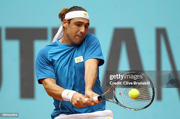 Marcos Baghdatis of Cyprus plays a backhand against Marco Chiudinelli of Switzerland in their first round match during the Mutua Madrilena Madrid...