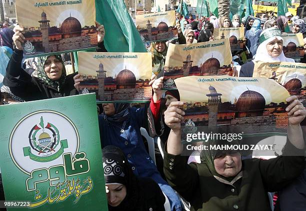 Palestinian refugee women in Lebanon hold pictures of Jerusalem's Dome of the Rock at the Al-Aqsa mosque compound during a protest against recent...