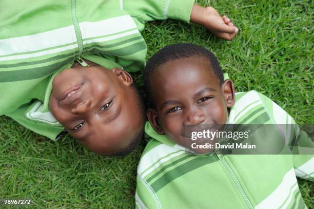 twin brothers (2-3) lying on grass, cape town, western cape province, south africa - malan stock pictures, royalty-free photos & images