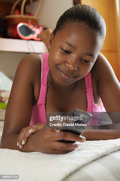 teenage girl (16-17) using mobile phone, cape town, western cape province, south africa - malan stockfoto's en -beelden
