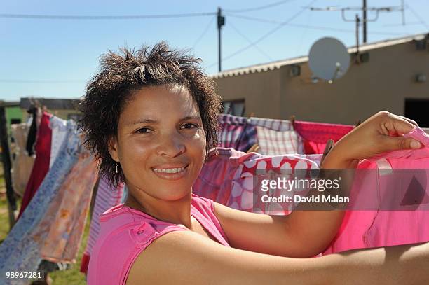 woman hanging up laundry, st francis bay, sea vista, eastern cape province, south africa - malan stockfoto's en -beelden