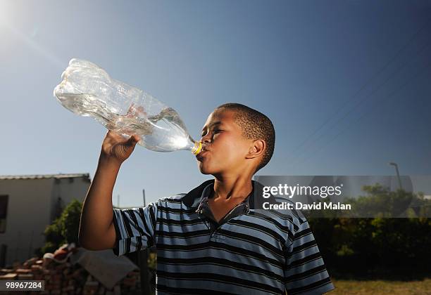 boy (12-13) drinking water from plastic bottle, st francis bay, sea vista, eastern cape province, south africa - eastern cape stockfoto's en -beelden