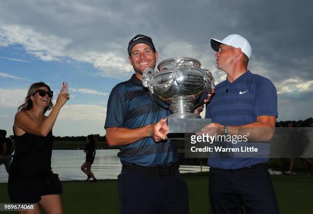 Alex Noren of Sweden and caddie Lee Warne pose with trophy as his wife Jennifer takes a picture after winning during the final round of the HNA Open...
