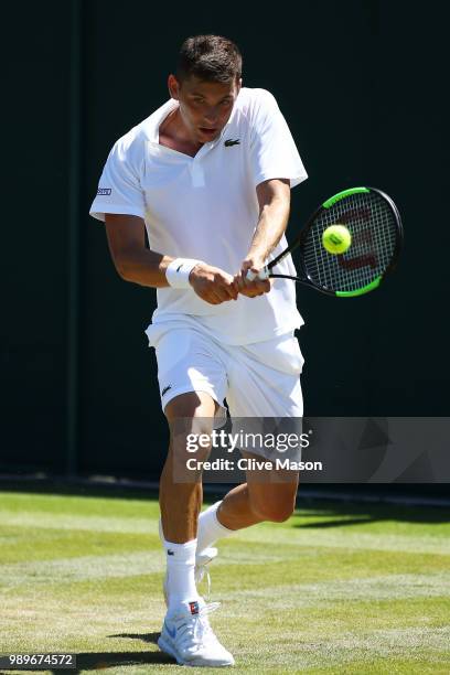 Filip Krajinovic of Serbia returns to Nicolas Jarry of Chile during their Men's Singles first round match on day one of the Wimbledon Lawn Tennis...