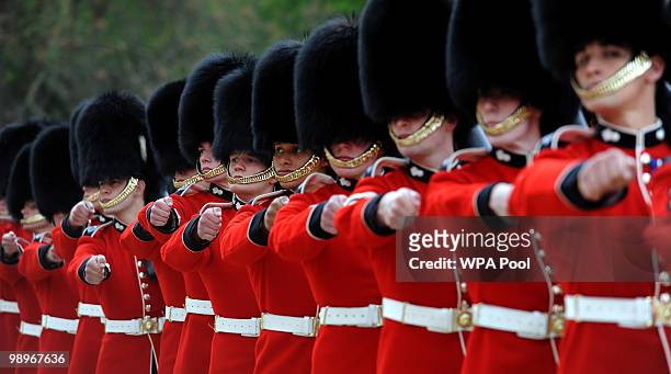 The Grenadier Guards march past Queen Elizabeth II after being presented with their new colours in the garden of Buckingham Palace on May 11, 2010 in...