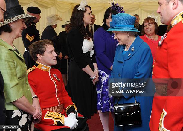 Queen Elizabeth II speaks with Lieutenant Garth Banks from the Grenadier Guards after presenting the regiment with their new colours on May 11, 2010...