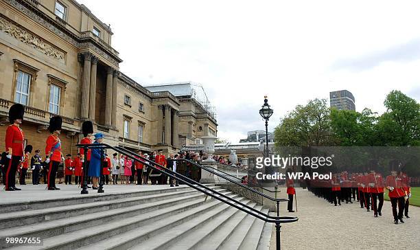 The Grenadier Guards march past Queen Elizabeth II after being presented with their new colours in the garden of Buckingham Palace on May 11, 2010 in...