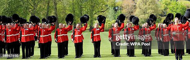 The Grenadier Guards cheer Queen Elizabeth II after she presented the regiment with new colours in the garden of Buckingham Palace on May 11, 2010 in...