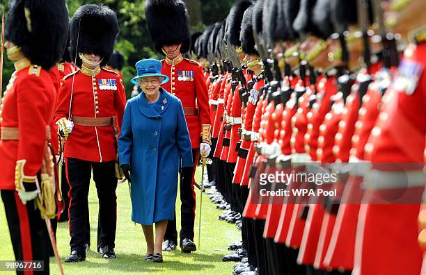 Queen Elizabeth II inspects the Grenadier Guards before presenting their new colours in the garden of Buckingham Palace on May 11, 2010 in London,...