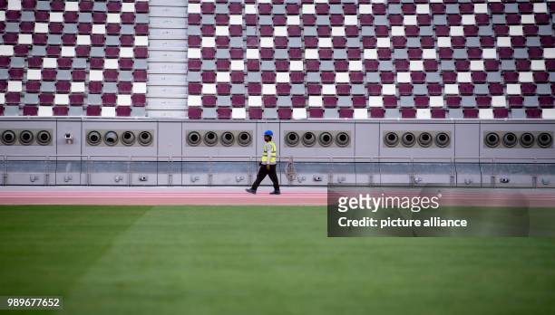 Ein Arbeiter läuft im Khalifa International Stadium in Doha am über die Laufbahn. Die Endrunde der Fußball-Weltmeisterschaft 2022 soll in Katar...