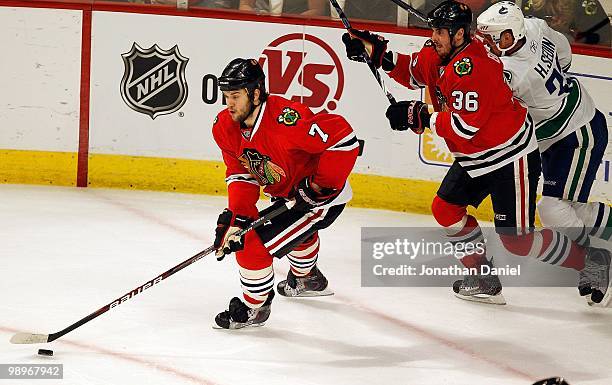 Brent Seabrook of the Chicago Blackhawks skates up the ice with the puck followed by teammate Dave Bolland and Henrik Sedin of the Vancouver Canucks...