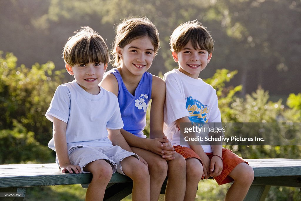 Two boys and a girl sit for family portrait