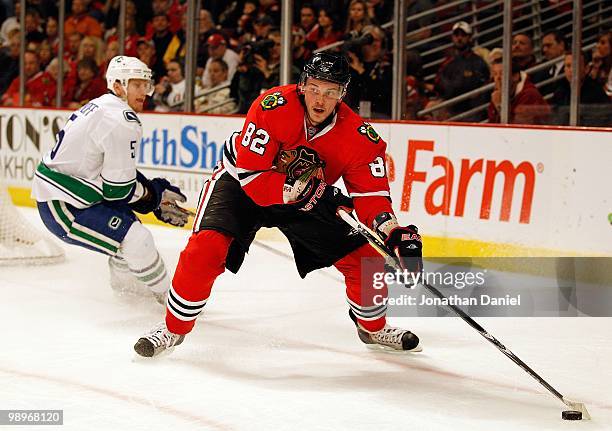 Tomas Kopecky of the Chicago Blackhawks looks to pass as Christian Ehrhoff of the Vancouver Canucks turns to defend in Game Five of the Western...