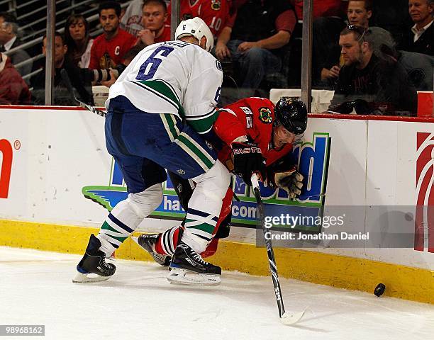 Tomas Kopecky of the Chicago Blackhawks is hit by Sami Salo of the Vancouver Canucks as he tries for the puck in Game Five of the Western Conference...