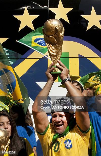 Holding copies of the World Cup trophy, Brazilian football fans await in front of a hotel in Rio de Janeiro, Brazil on May 11, 2010 the announcement...