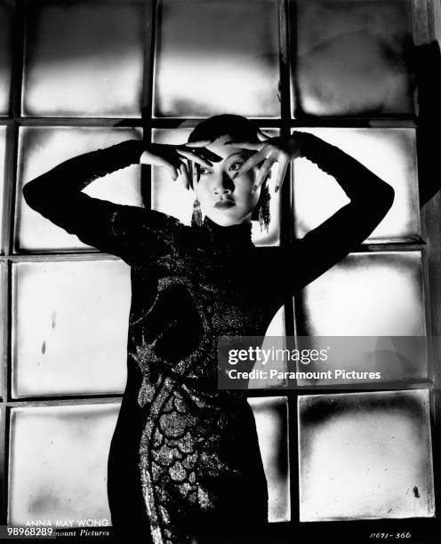 Chinese-American film star Anna May Wong wearing a dress with dragon motif in a publicity shot for 'Limehouse Blues', 1934.