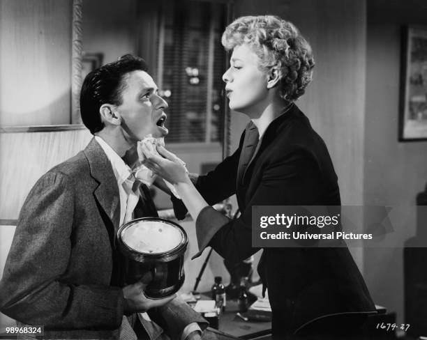 American actress Shelley Winters tends to Frank Sinatra's bruised jaw in a scene from the film 'Meet Danny Wilson', 1951.