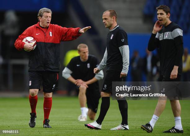 Head coach Roy Hodgson gives instructions to his players Danny Murphy and Zoltan Gera during the Fulham training session ahead of the UEFA Europa...
