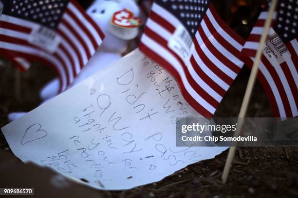 Flowers, flags and hand-written notes are gathered in a makeshift memorial outside the Annapolis Capitol Gazette offices for the employees killed by...