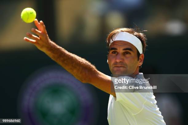 Roger Federer of Switzerland serves to Dusan Lajovic of Serbia during their Men's Singles first round match on day one of the Wimbledon Lawn Tennis...
