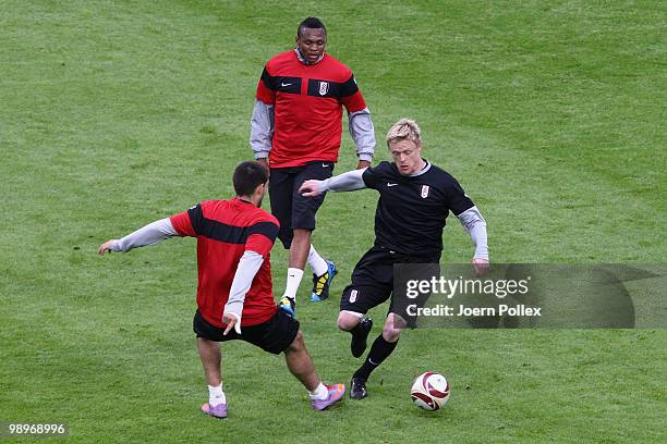 Damien Duff is challenged by Clint Dempsey while Kagisho Dikgacoi looks on during the Fulham press conference ahead of the UEFA Europa League final...