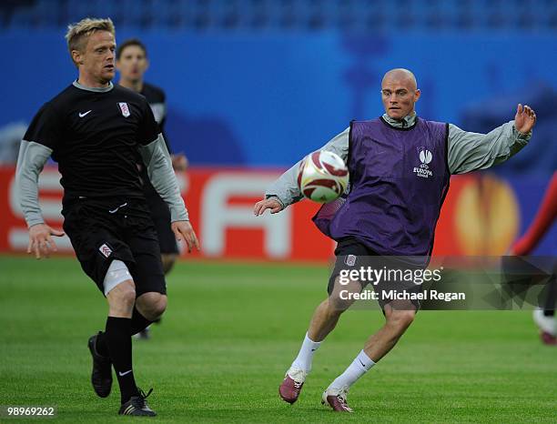 Paul Konchesky is challenged by Damien Duff during the Fulham training session ahead of the UEFA Europa League final match against Atletico Madrid at...