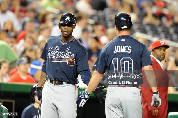 Chipper Jones of the Atlanta Braves is congratulated by Jason Heyward after scoring against the Washington Nationals at Nationals Park on May 4, 2010...