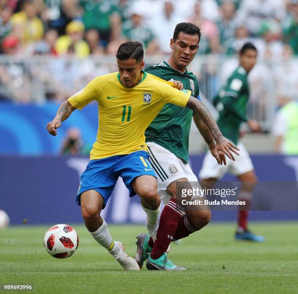 Philippe Coutinho of Brazil is challenged by Rafael Marquez of Mexico during the 2018 FIFA World Cup Russia Round of 16 match between Brazil and...