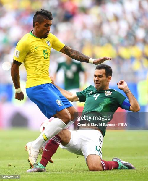 Paulinho of Brazil is challenged by Rafael Marquez of Mexico during the 2018 FIFA World Cup Russia Round of 16 match between Brazil and Mexico at...