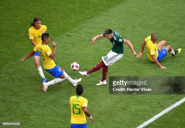 Hector Herrera of Mexico attempts a shot past Casemiro and Filipe Luis of Brazil during the 2018 FIFA World Cup Russia Round of 16 match between...