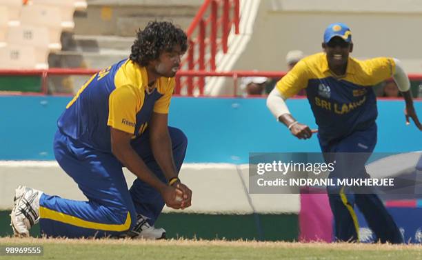 Sri Lankan cricketer Lasith Malinga takes the catch of Indian cricketer Dinesh as teammate Thissara Perera looks on during the ICC World Twenty20...