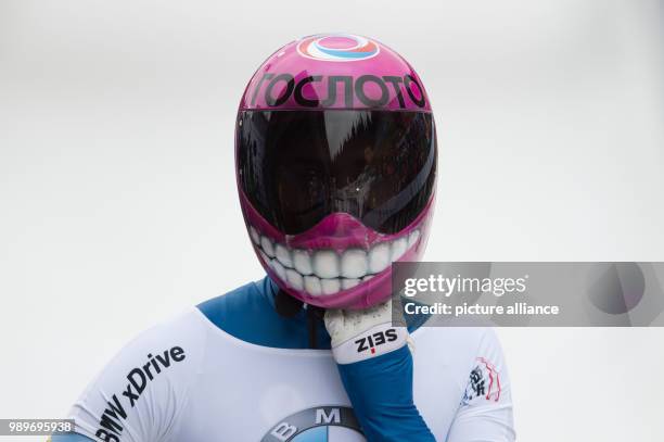 Russia's Elena Nikitina takes off her helmet in the finish line area after her second run at the women's Skeleton World Cup in Altenberg, Germany, 05...