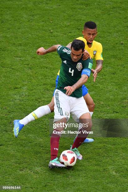Rafael Marquez of Mexico passes thre ball under pressure from Gabriel Jesus of Brazil during the 2018 FIFA World Cup Russia Round of 16 match between...