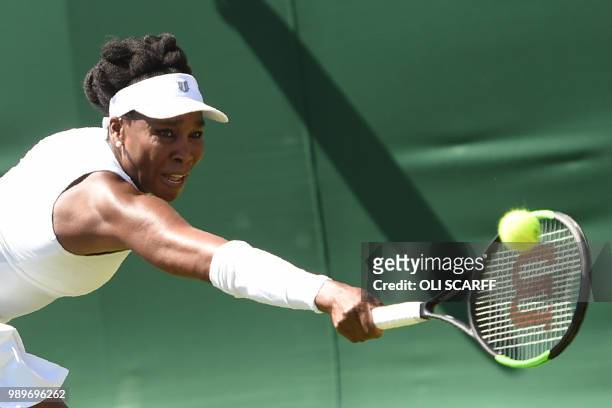 Player Venus Williams returns to Sweden's Johanna Larsson during their women's singles first round match on the first day of the 2018 Wimbledon...