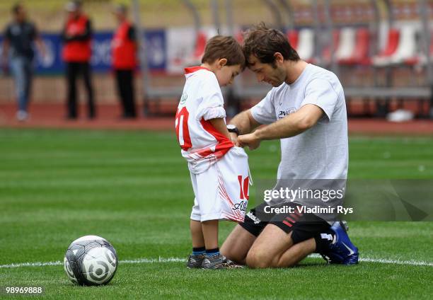 Jarno Trulli of Italy and Lotus is pictured with his son ahead the football charity match between the Monaco star team and the team of formula one...