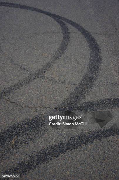 tyre skidmarks on an asphalt road - skid marks fotografías e imágenes de stock