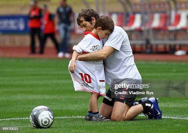 Jarno Trulli of Italy and Lotus is pictured with his son ahead the football charity match between the Monaco star team and the team of formula one...