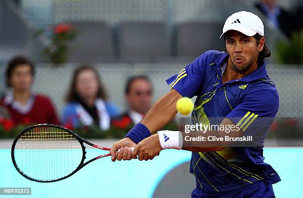 Fernando Verdasco of Spain plays a backhand against Ivo Karlovic of Croatia in their second round match during the Mutua Madrilena Madrid Open tennis...