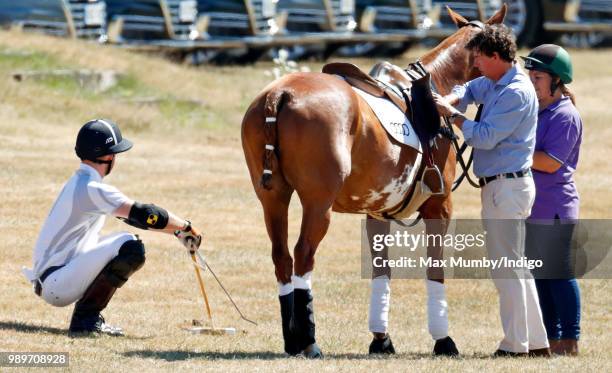 Prince Harry, Duke of Sussex stretches before taking part in the Audi Polo Challenge at Coworth Park Polo Club on June 30, 2018 in Ascot, England.