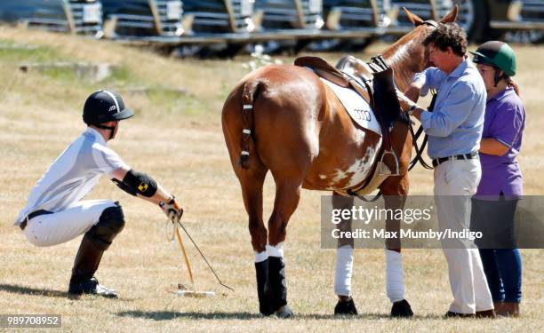 Prince Harry, Duke of Sussex stretches before taking part in the Audi Polo Challenge at Coworth Park Polo Club on June 30, 2018 in Ascot, England.