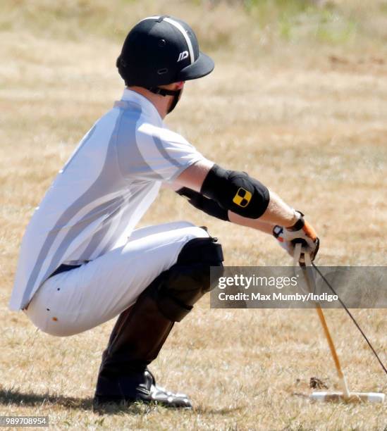 Prince Harry, Duke of Sussex stretches before taking part in the Audi Polo Challenge at Coworth Park Polo Club on June 30, 2018 in Ascot, England.