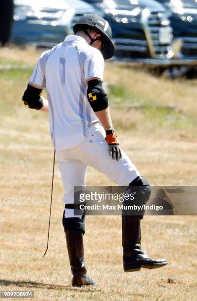 Prince Harry, Duke of Sussex stretches before taking part in the Audi Polo Challenge at Coworth Park Polo Club on June 30, 2018 in Ascot, England.