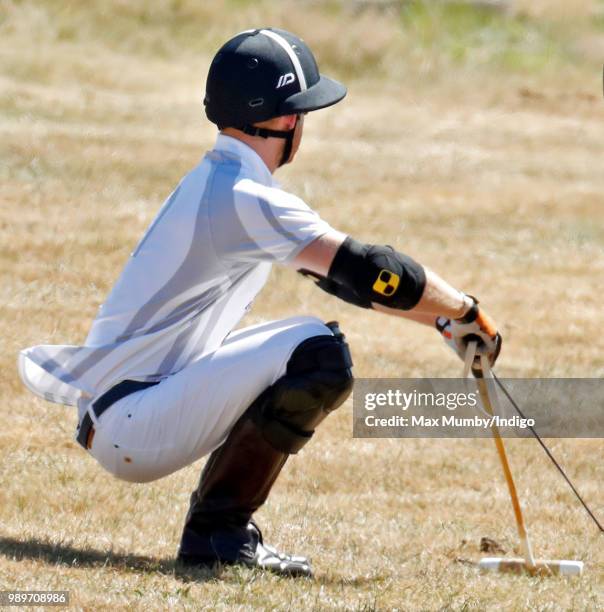 Prince Harry, Duke of Sussex stretches before taking part in the Audi Polo Challenge at Coworth Park Polo Club on June 30, 2018 in Ascot, England.