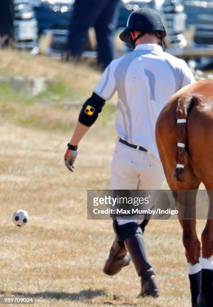 Prince Harry, Duke of Sussex kicks a football before taking part in the Audi Polo Challenge at Coworth Park Polo Club on June 30, 2018 in Ascot,...