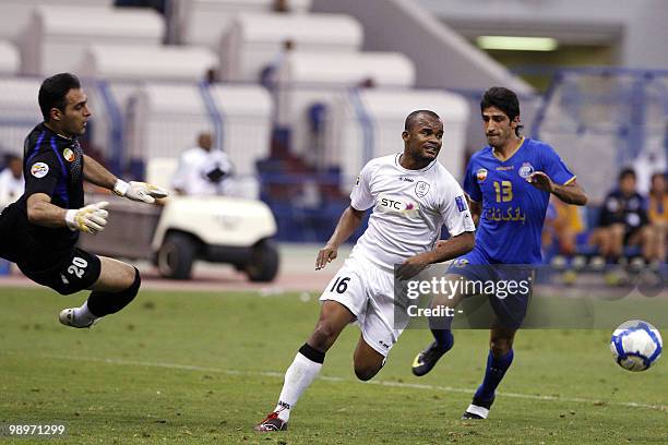 Saudi Al-Shabab club player Amado Flavio runs after the ball as Mohsen Yousefi and goalkeeper Mohammad Mohammadi of Iran's Esteghlal club vie with...
