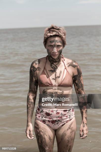 serious woman standing in water - saint simons island 個照片及圖片檔