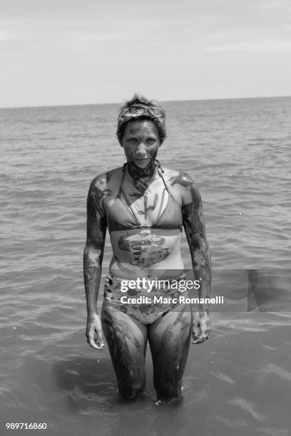 serious woman standing in water - saint simons island stockfoto's en -beelden