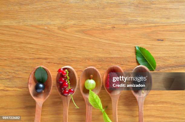 top view of berries mixed (raspberry, black currant, red currant, gooseberry, blackberry) on wooden - gooseberry - fotografias e filmes do acervo