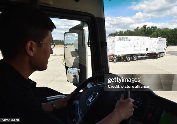 July 2018, Germany, Selchow: A man driving a truck during a demonstration of platooning in autonomous driving in the unused south strip of...